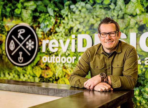 Dave Sether, president of ReVi Design, stands in his lobby at a counter.
