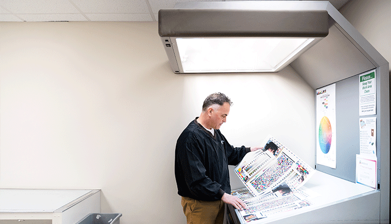 A man looks over proofs at Reindl Printing, Inc.