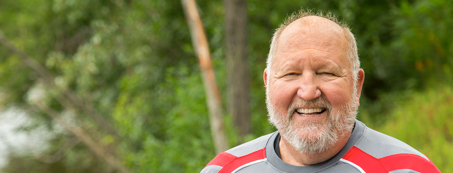 man smiling outside on a summer day