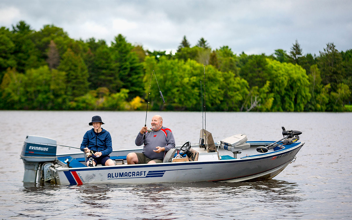 grandfather and grandson fishing in a boat