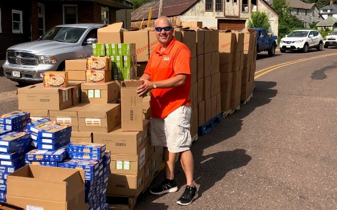 Un empleado voluntario de IncredibleBank preparando las cajas de alimentos.