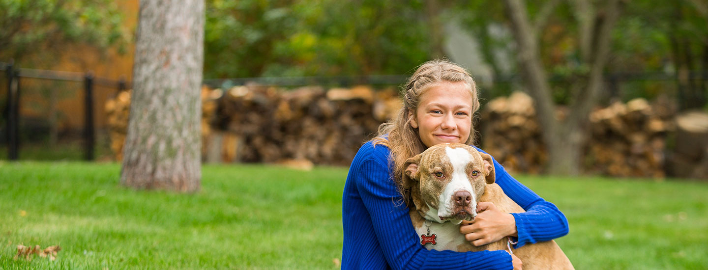 young girl outside in the yard with dog