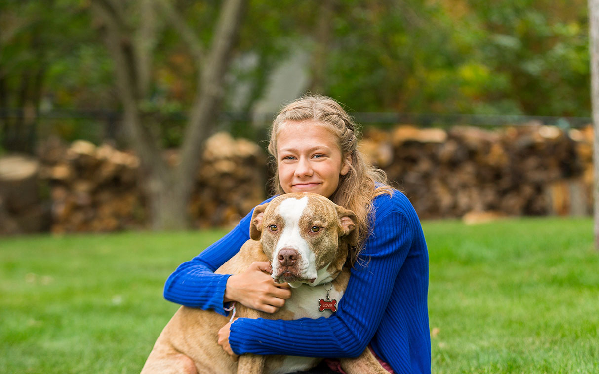 young girl outside playing with her dog