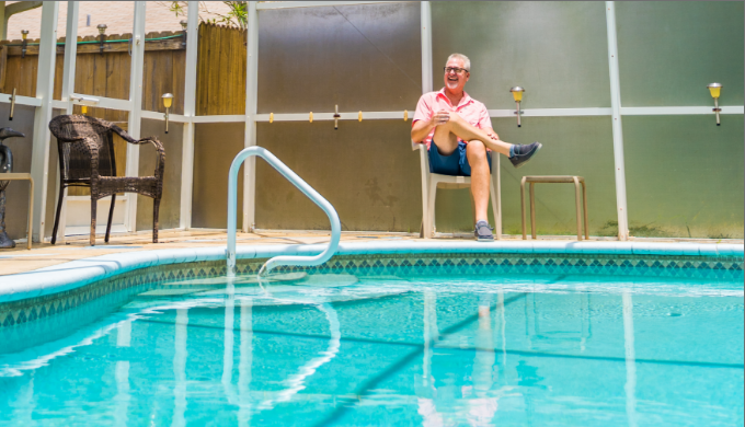 Don Hopkins, cliente de una hipoteca con IncredibleBank, sentado en una silla junto a su piscina.