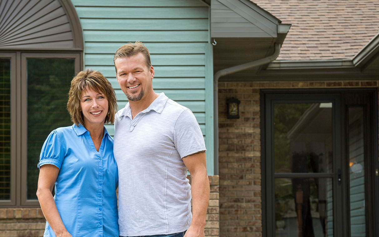 couple smiling outside their home