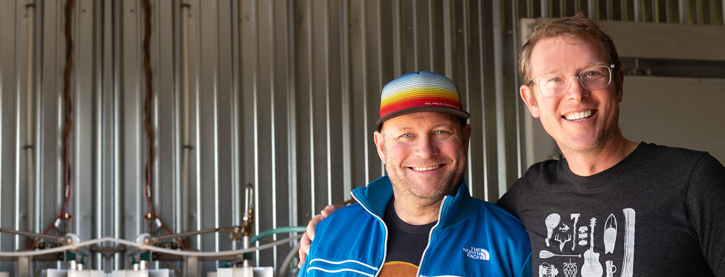 Brewery owners in front of their equipment