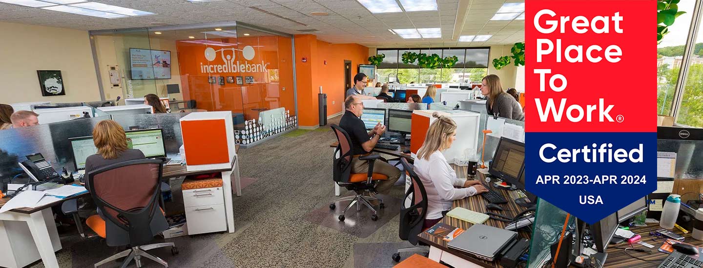 A bright office setting with employees working at their desks.