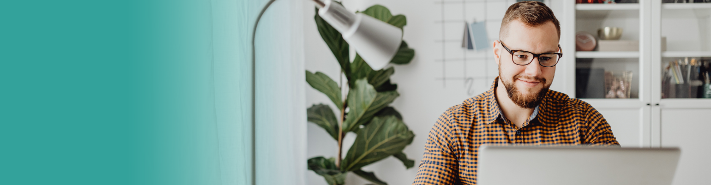 Un hombre con gafas mirando una computadora portátil