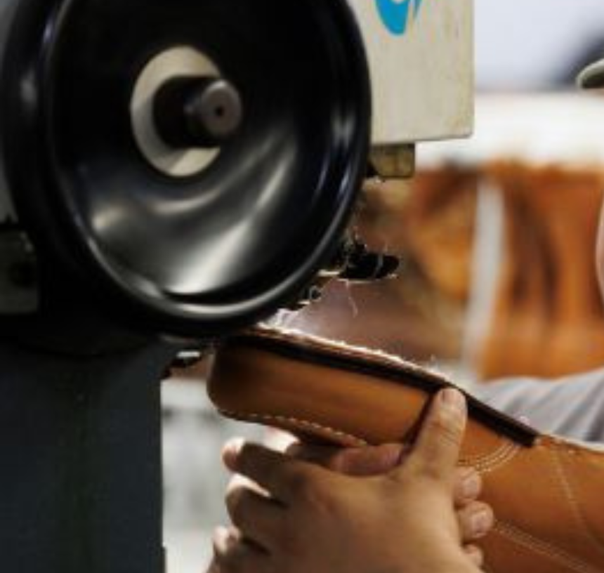 Craftsperson finishing leather by hand in a small business workshop