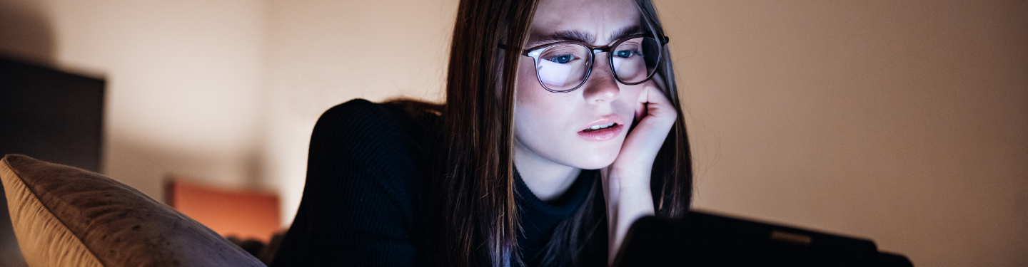 Woman looking at laptop with eyebrows furrowed