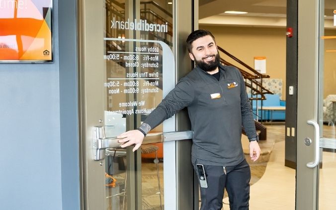 An IncredibleBank employee offering a warm welcome at the branch, delivering an Incredible Customer Experience (ICE) from the moment you walk in.