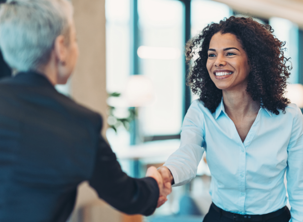 Two businesswomen shaking hands in an office