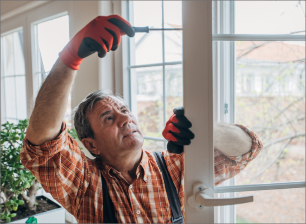 Man using a screwdriver to fix a door