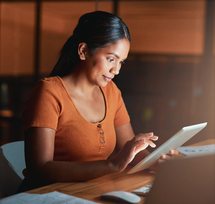 Woman looking at tablet in dark room