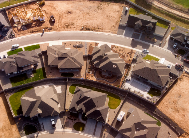 Overhead view of houses in a neighborhood with one house still being built and two empty lots